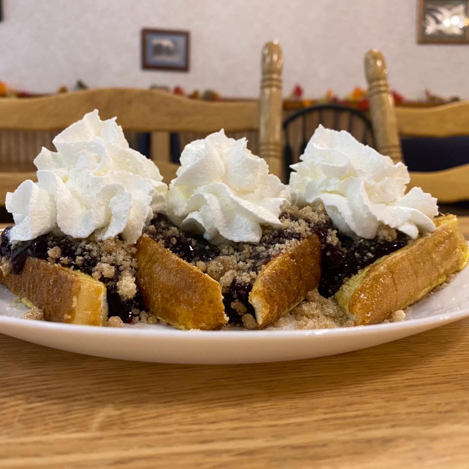 french toast topped with blueberry crumble and whipped cream